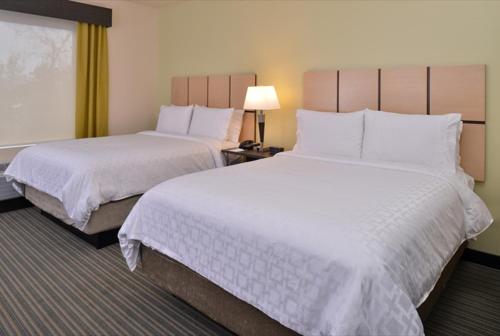 a hotel room with two beds with white sheets at Candlewood Suites - Austin Airport, an IHG Hotel in Austin