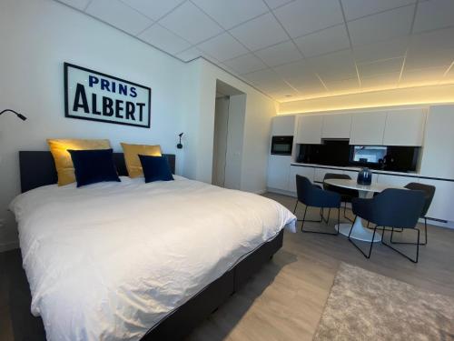 a bedroom with a large bed and a dining room at Baelskaai Harbor Apartment in Ostend
