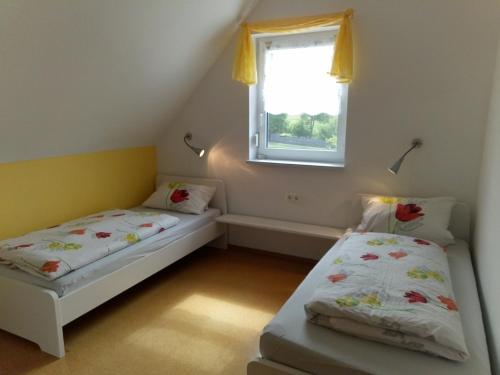 two beds in a small room with a window at Ferienanlage Karolinenhof in Haundorf