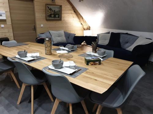un grande tavolo in legno in un soggiorno con divano di chambres d’hôte le breuil a Sarlat-la-Canéda