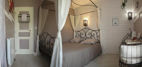 a bedroom with a large bed with a canopy at Au Coeur Du Bien Etre, chambre d'hôtes avec piscine chauffée et couverte, SPA, sauna, massages in Monteaux