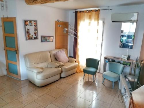 un salon avec un canapé et deux chaises dans l'établissement Chambre chez l'habitant, à Tourbes