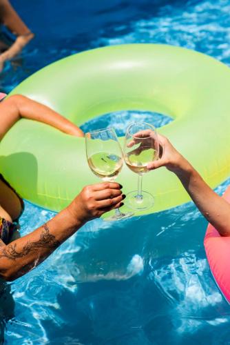 two people holding wine glasses in a swimming pool at Casa Amberes in Honda