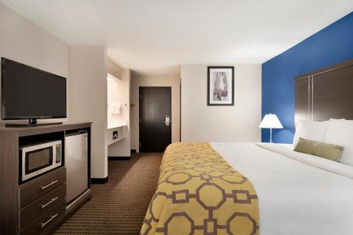 a hotel room with a bed and a flat screen tv at Baymont by Wyndham Casa Grande in Casa Grande