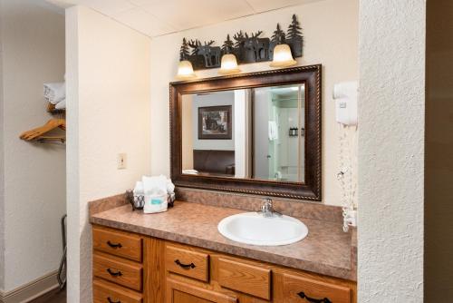 a bathroom with a sink and a mirror at Creekstone Inn in Pigeon Forge