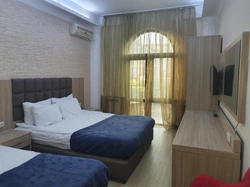 a hotel room with two beds and a window at City Star Hotel in Batumi