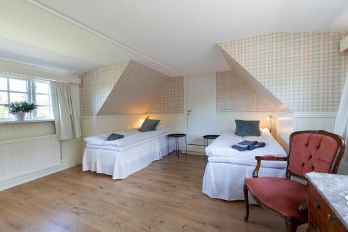 Cette chambre comprend deux lits, une table et des chaises. dans l'établissement Husargårdens Bed & Breakfast, à Sjöbo