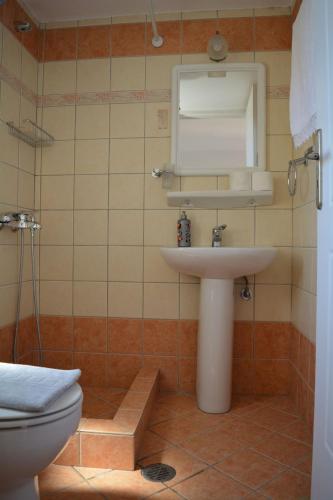 a bathroom with a sink and a toilet at Volta Superior Studios in Avlemonas