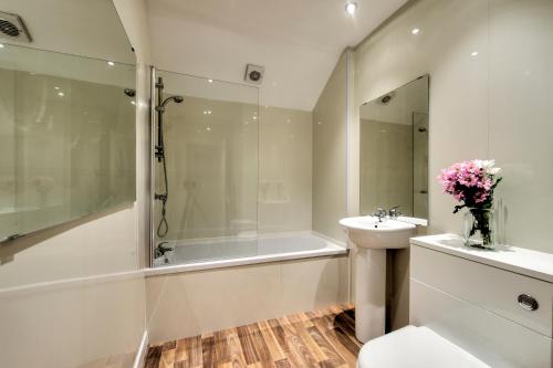 a bathroom with a tub and a sink and a shower at Oaktree Appartment Moffat in Moffat