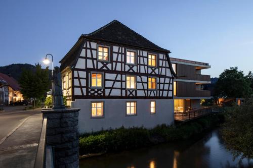 a black and white building next to a river at Sternen Bohlingen Aparthotel in Bohlingen