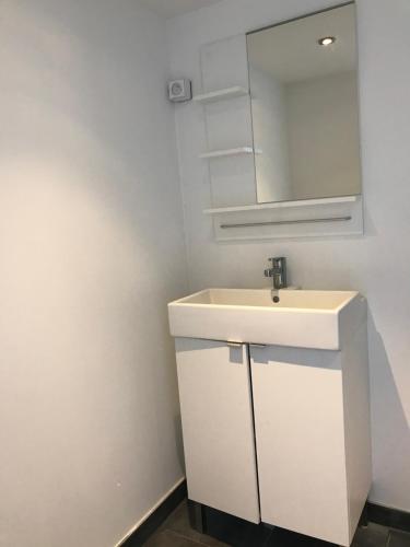 ein Badezimmer mit einem weißen Waschbecken und einem Spiegel in der Unterkunft Tente Lodge les Gîtes de l'Odet in Lanio