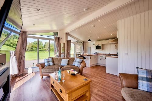 uma sala de estar com um sofá e uma mesa em Silverwood Luxury Lodges & Bistro Barn em Perth