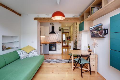 a living room with a green couch and a table at Apartments Forum 2 in Pula