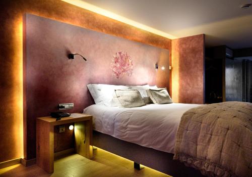 a bedroom with a large bed with a wall at Boutique hotel Urbisol in Calders