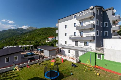 an apartment building with a yard with a playground at Resort Bevilacqua in Budva