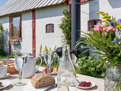 een tafel met een fles wijn en brood en glazen bij 6 person holiday home in Nex in Neksø