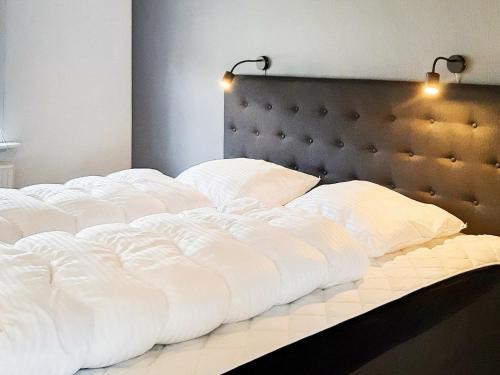 1 cama grande con sábanas blancas y almohadas. en Holiday home Skagen XXX, en Skagen