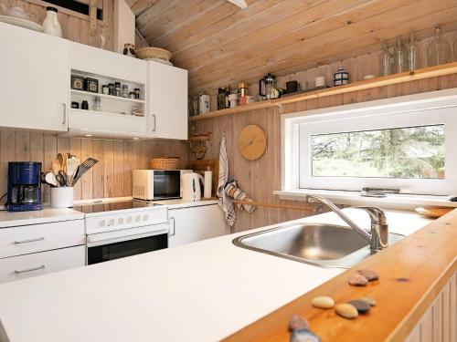 Kandestederneにある7 person holiday home in Skagenの白いキャビネット、シンク、窓付きのキッチン