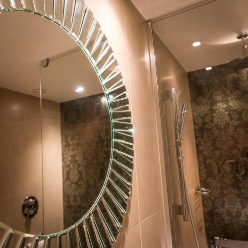 a bathroom with a mirror and a shower at Hotel Indigo Glasgow by IHG in Glasgow