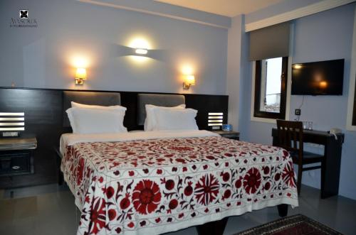 a bedroom with a bed with a red and white blanket at Ayasoluk Hotel & Restaurant in Selcuk