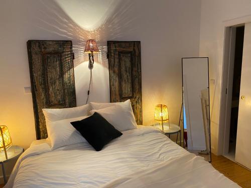 een slaapkamer met een wit bed en een zwart kussen bij Old Town Terrace Apartment in Évora