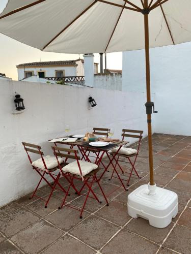 een tafel en stoelen met een parasol op een terras bij Old Town Terrace Apartment in Évora