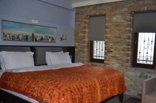 a bedroom with a large bed and two windows at Ayasoluk Hotel & Restaurant in Selcuk