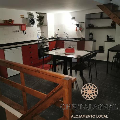 une cuisine avec une table et des chaises dans l'établissement CHR Talasnal, à Lousã
