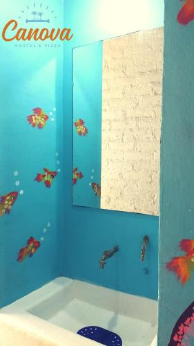 a mirror in a bathroom with fish on the wall at Canova Hostel & Pizza in Puerto Vallarta