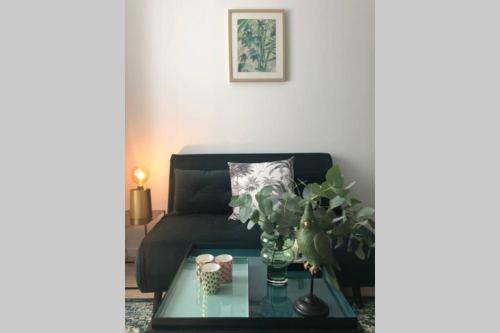 a living room with a couch and a glass table at Maison la Déco Verte in Braine