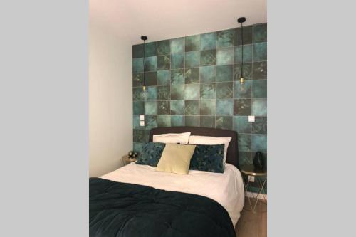 um quarto com uma cama e uma parede em azulejo verde em Maison la Déco Verte em Braine