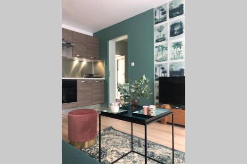 a living room with a table and a kitchen at Maison la Déco Verte in Braine