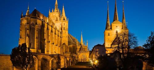 a large cathedral with two towers at night at Privatzimmer in Erfurt