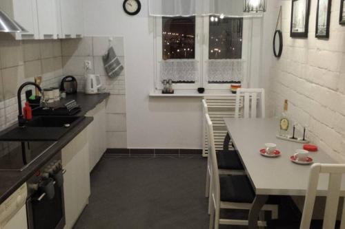 a kitchen with a table and a sink and a table and chairs at Apartament MORSKA 148 Gdynia 65m2 in Gdynia