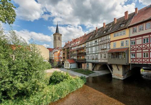 una città con un ponte su un fiume con edifici di Privatzimmer a Erfurt