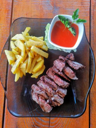 a plate of meat and french fries and sauce at Casa Suzy & Roxy in Arpaşu de Jos