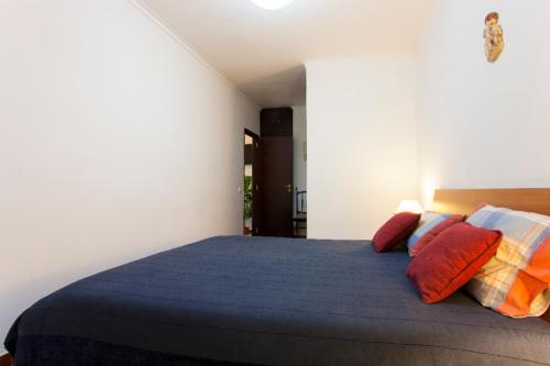 a bedroom with a bed with colorful pillows at Casa de Praia in Costa da Caparica