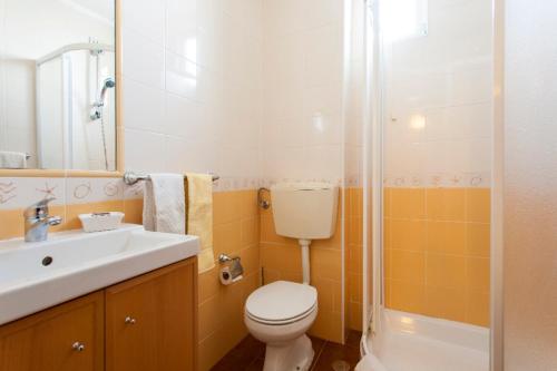 a bathroom with a toilet and a sink and a shower at Casa de Praia in Costa da Caparica