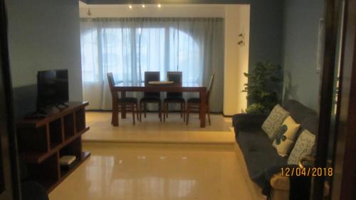 a living room with a table and a couch at Casa de Praia in Costa da Caparica