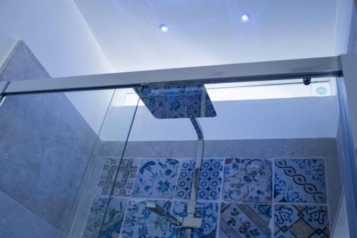 La salle de bains est pourvue d'une douche en verre et d'un sol en verre. dans l'établissement La Dimora sotto le Stelle, à Noto