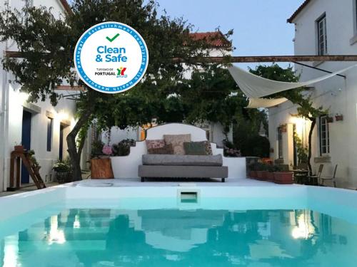a swimming pool in a villa with a sign that says clean and safe at Oryza Guest House& Suites in Coimbra