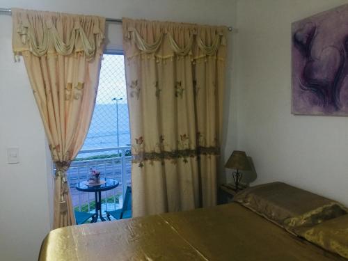 um quarto com uma cama e uma janela com vista em Vista Mar Massaguaçu em Caraguatatuba