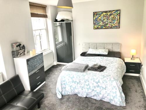 1 dormitorio con 1 cama y 1 silla en Camden Guest House Super king or Double Bedroom, en Londres