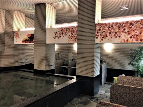 a lobby of a hotel with pink flowers on the wall at Hotel Hokke Club Hiroshima in Hiroshima