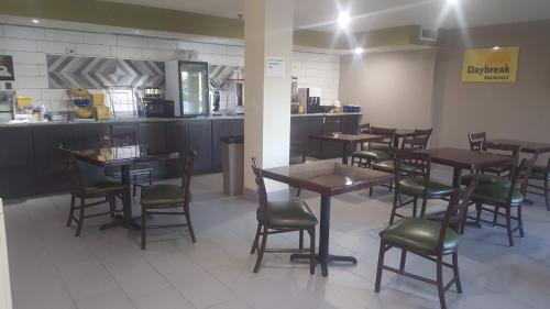 a restaurant with tables and chairs and a kitchen at Days Inn by Wyndham West Des Moines - Clive in Clive