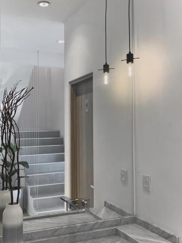 a lobby with a staircase and a vase with a plant at Hotel Blanco Pachuca in Pachuca de Soto