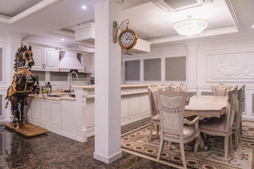a white kitchen with a table and a clock at Amazing Pool Villas in Pattaya