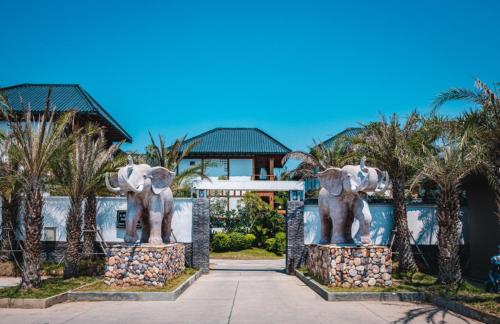 two statues of elephants in front of a building at Amazing Pool Villas in Pattaya
