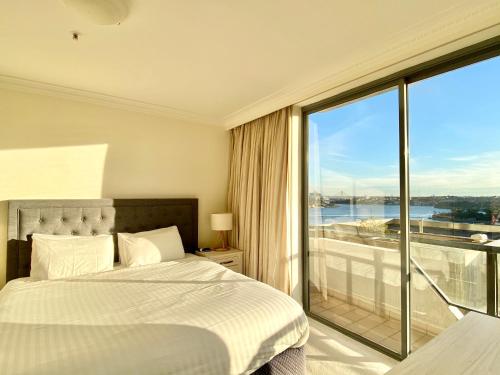 a bedroom with a bed and a large window at Milson Serviced Apartments in Sydney