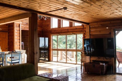 a living room with a flat screen tv in a house at Vibe Naftali Estate in Ramot Naftali